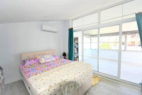 ein Schlafzimmer mit einem Bett und einem großen Fenster in der Unterkunft Villa HUZUR in Side
