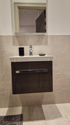 a bathroom with a sink and a mirror at London Tottenham Stadium Apartment in London