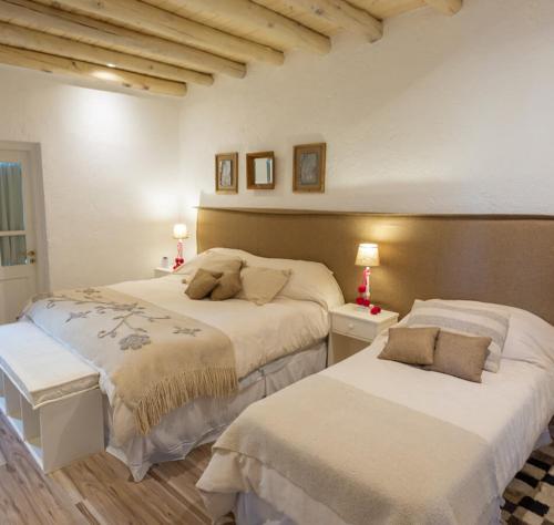 a bedroom with two beds and two lamps in it at Durigutti Family Winemakers - Casas de Huéspedes in Las Compuertas