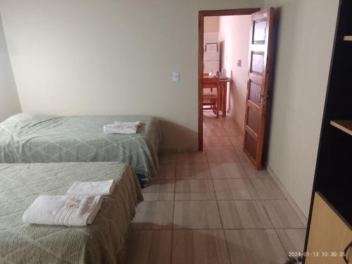 a room with two beds and a hallway with a table at Alojamiento Huazhiul Barreal in Barreal