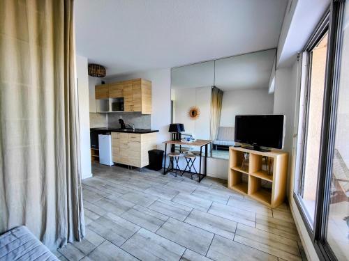 Il comprend un salon avec une télévision et une cuisine. dans l'établissement Joli studio à la Grande Motte, à La Grande Motte