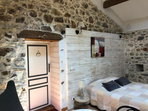 ChamborigaudにあるMas la Tabatièreの石壁のベッドルーム1室(ベッド1台付)