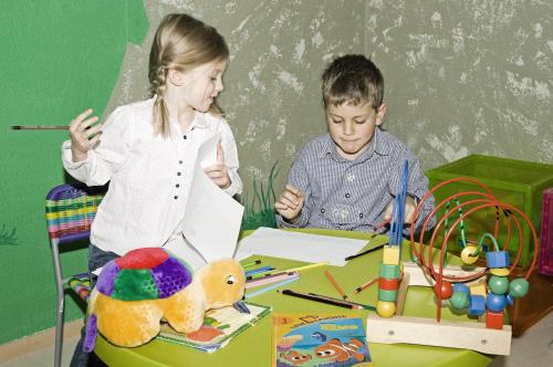 a boy and a girl playing with toys at a table at Hotel Alpen Residence in Ehrwald