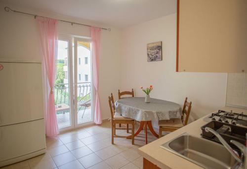eine Küche mit einem Tisch, einem Tisch und einem Fenster in der Unterkunft Apartments Plenković in Stari Grad