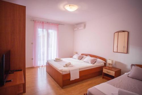 ein Schlafzimmer mit einem Bett, einem Spiegel und einem TV in der Unterkunft Apartments Plenković in Stari Grad