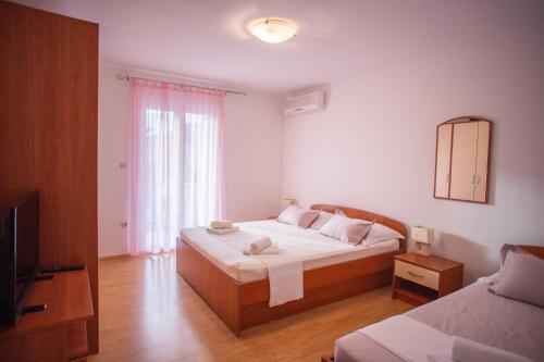 a bedroom with a bed and a mirror and a television at Apartments Plenković in Stari Grad