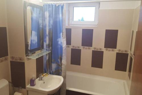 a bathroom with a sink and a shower curtain at Three room apartment in Cluj-Napoca