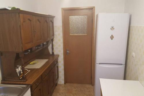 uma cozinha com um frigorífico branco e uma porta castanha em Three room apartment em Cluj-Napoca