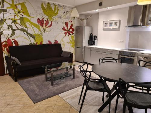 a living room with a black couch and a table at Wigwam Apartament 6-osobowy in Sopot