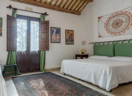 1 dormitorio con cama y ventana grande en Casale Colomba, en Buseto Palizzolo