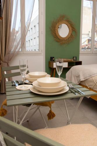 une table verte avec des assiettes et des verres à vin dessus dans l'établissement La bohème au Vieux-Port, à Marseille