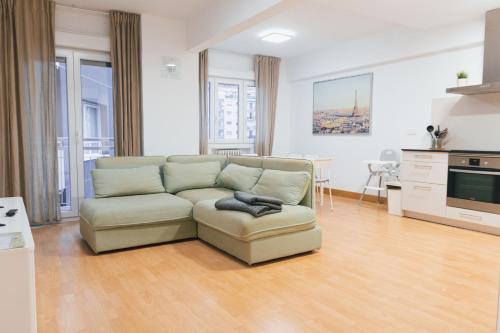 ein Wohnzimmer mit Couch und Küche in der Unterkunft Apartamento familiar reformado en Amara, Estadio Anoeta, Donostia-San Sebastián in San Sebastián