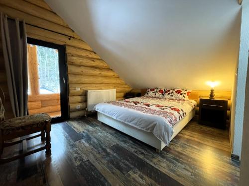 a bedroom with a bed in a log cabin at Cabana Butura in Negulesti