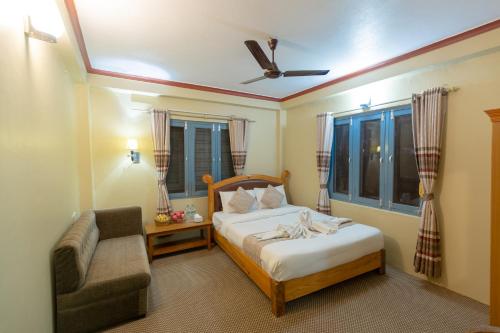 una camera da letto con un letto, una sedia e un divano di Paradise Boutique Hotel a Pokhara