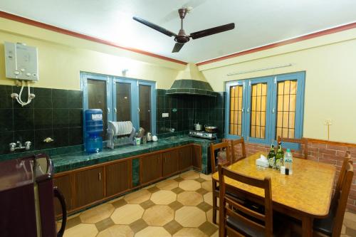 a large kitchen with a table and a ceiling fan at Paradise Boutique Hotel in Pokhara