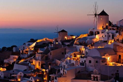 a view of a village at night at Lioyerma Windmill Villa With Outdoor Hot Tub in Oia