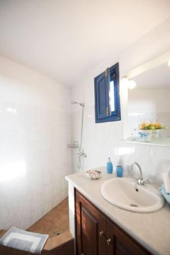 a bathroom with a sink and a mirror at Lioyerma Windmill Villa With Outdoor Hot Tub in Oia