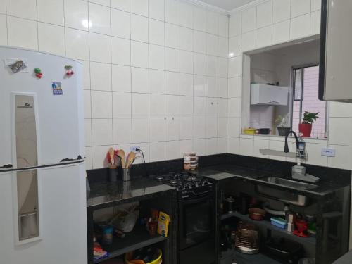 een keuken met een fornuis en een koelkast bij Apto boqueirão Praia Grande 800 MTS Praia in Praia Grande
