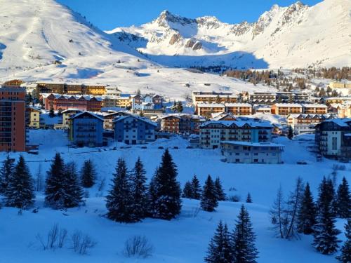 a city covered in snow with mountains in the background at Bella Mapi in Passo del Tonale