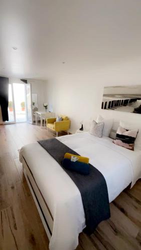 ein großes weißes Bett in einem weißen Zimmer mit in der Unterkunft Chambre le Petit Olivier in Arles