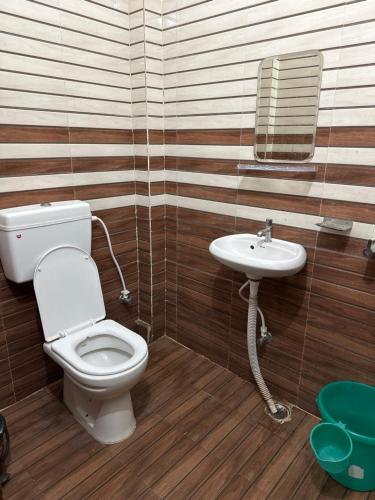 a bathroom with a toilet and a sink at Hotel Sharda Palace in Deoghar