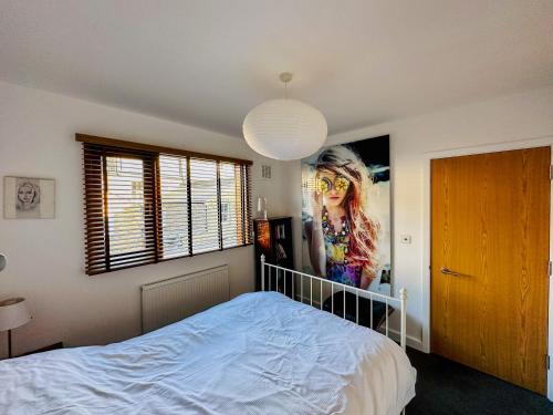 a bedroom with a bed and a poster of a woman at Sunny Room in Highbury in London