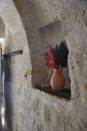 un jarrón sentado en un estante en una pared de piedra en cemil köyü cave house en Urgup