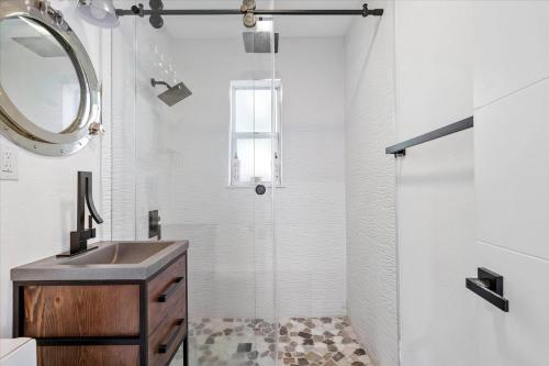 a bathroom with a shower and a sink and a mirror at Private Fort Lauderdale cottage in Fort Lauderdale