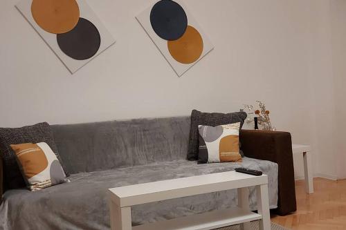 a living room with a gray couch and a table at Sunflower apt in Timişoara