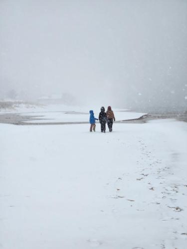 three people walking on the beach in the snow at Weathervane Inn in Montague