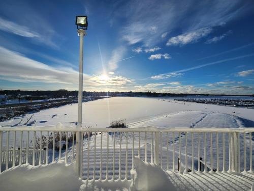 a white fence with a light pole in the snow at Weathervane Inn in Montague