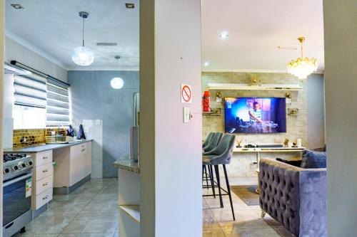 a kitchen with a tv on the wall at Homes of Ace 3 bedroom Villa in Pretoria