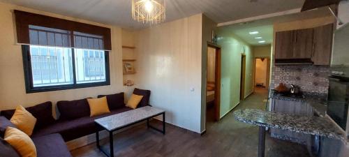 ein Wohnzimmer mit einem Sofa und einer Küche in der Unterkunft StOony in Agadir