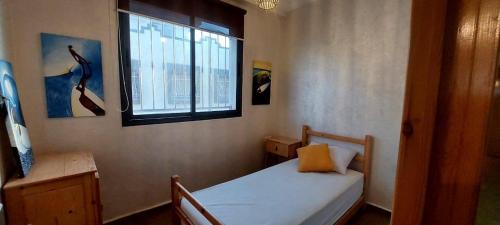 ein kleines Schlafzimmer mit einem Bett und einem Fenster in der Unterkunft StOony in Agadir