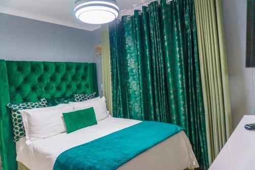 a bedroom with a green headboard and green curtains at Homes of Ace 3 bedroom Villa in Pretoria