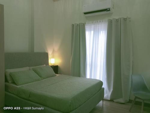 1 dormitorio con cama y ventana en Condo with Balcony in Iloilo City, en Iloilo City