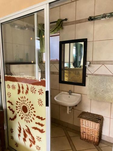 a bathroom with a sink and a mirror at Five Stars Lodge in Phalaborwa