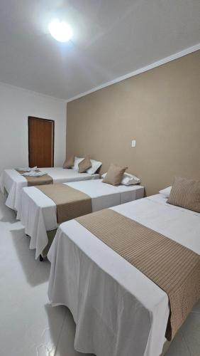 um grupo de quatro camas num quarto em Pousada Casa Bella em Itaberaba