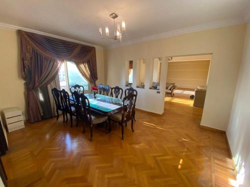a dining room with a table and chairs on a wooden floor at warm lovely capacious sunny unit in Cairo