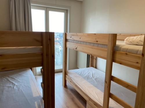 two bunk beds in a room with a window at Kristof701 in De Panne