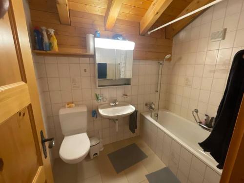 y baño con aseo, lavabo y bañera. en 3-Zimmer Maisonette-Wohnung, en Bürchen
