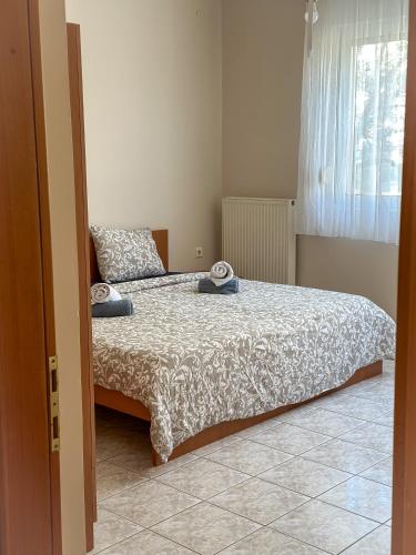 a bedroom with a bed and a window at Ground Apartment AXD in Alexandroupoli