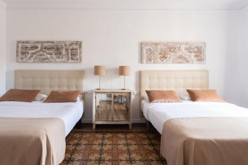 2 camas en una habitación con paredes blancas en Sunny rooms bcn, en Barcelona