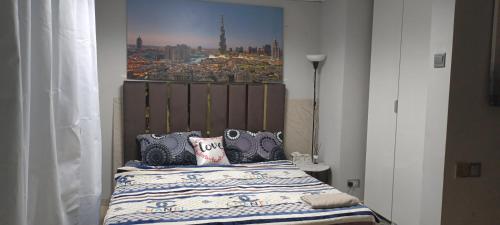a bedroom with a bed with a picture on the wall at Ocean view 8min from the beach Dubai Marina JBR " My Home " in Dubai