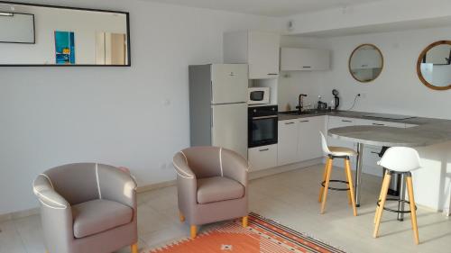 une cuisine avec deux chaises et une table dans l'établissement Harbour View Apartment, à Marseillan