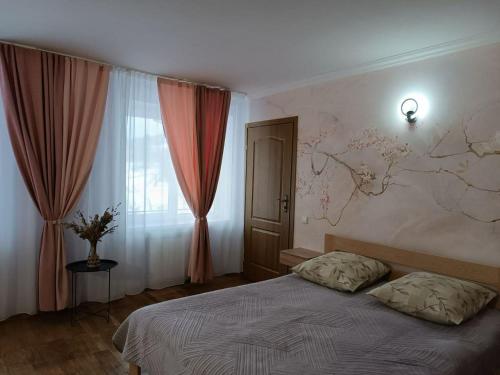 ein Schlafzimmer mit einem Bett und einer Karte an der Wand in der Unterkunft Вілла На Гірській in Schidnyzja