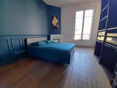 a blue bedroom with a bed and a window at Magnifique maison avec terrasse in Château-Thierry