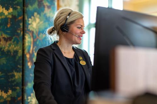 a woman with a headset and a computer at Hooks Herrgård in Hok