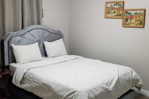 a bedroom with a bed with white sheets and pillows at Cozy Luxurious Detached 4 Bedroom House in Guelph