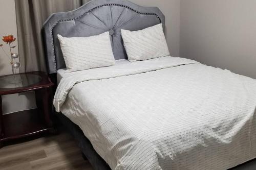 um quarto com uma cama branca e uma cabeceira de metal em Cozy Luxurious Detached 4 Bedroom House em Guelph